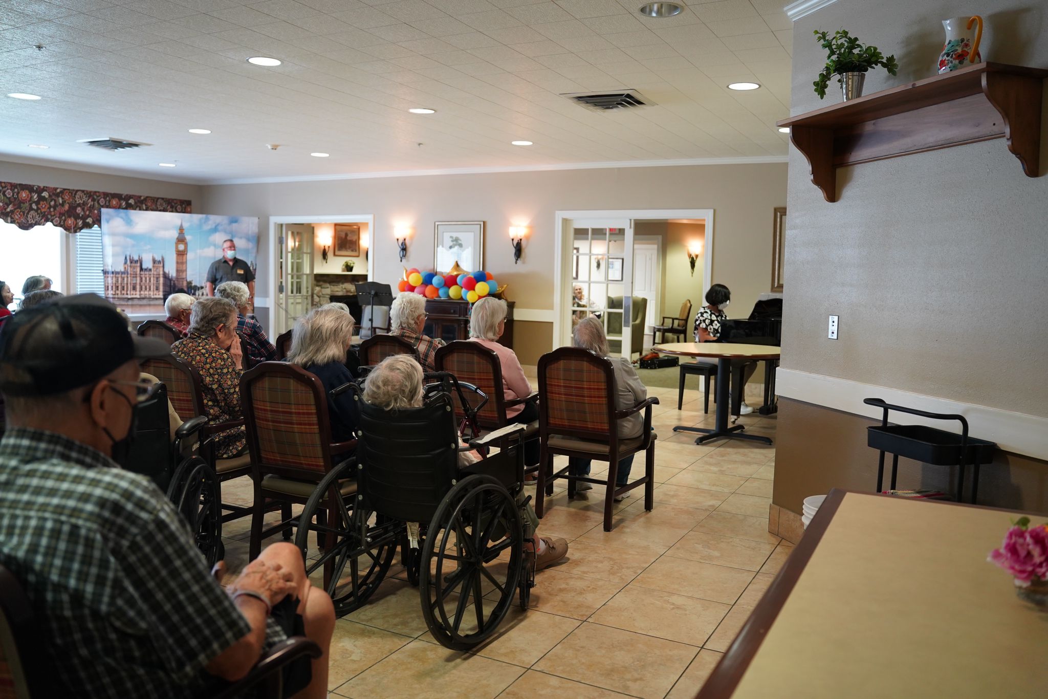 A musician playing the piano in a care home with elderly residents